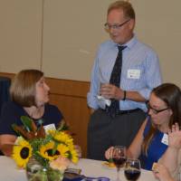 Four alumni enjoying conversation at the table